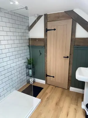 a bathroom with a wooden door and a sink at The Swan in Munslow