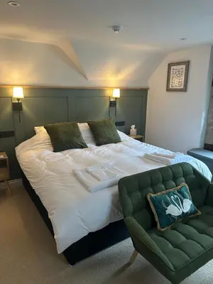 a bedroom with a large bed and a green couch at The Swan in Munslow