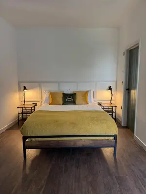a bedroom with a large bed with two side tables at The Library Cottage at The Old Library in Aberystwyth