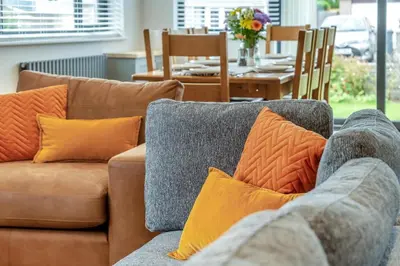 a couch with orange and gray pillows in a living room at 4 Bed in Brecon oc-m32973 in Brecon