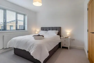 a white bedroom with a large bed and a window at 4 Bed in Brecon oc-m32973 in Brecon