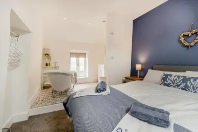 a bedroom with a large bed and a bath tub at 3 Bed in Tywyn oc-h32633 in Tywyn
