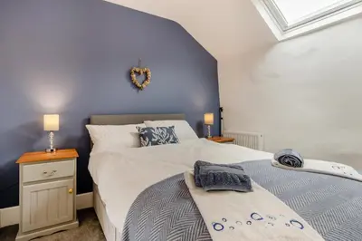 a bedroom with two beds and a blue wall at 3 Bed in Tywyn oc-h32633 in Tywyn