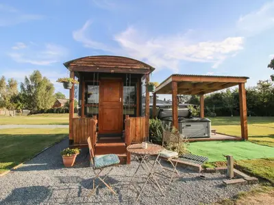 a gazebo with a grill in a yard at Sharon's Shepherd Hut in Oswestry