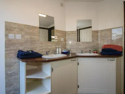 a bathroom with two sinks and two mirrors at Sharon's Shepherd Hut in Oswestry