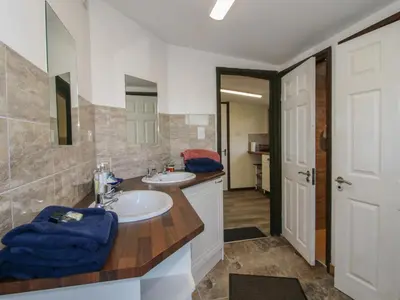 a bathroom with a sink and a mirror at Sharon's Shepherd Hut in Oswestry