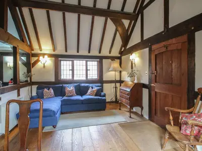a living room with a blue couch and a window at The Coach House in Church Stretton