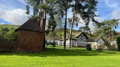 an old brick building in the middle of a field at Courtyard Cottage in Church Stretton