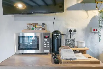 a microwave sitting on top of a wooden table at Charming Welsh Cottage in Dolgellau - Snowdonia in Dolgellau
