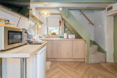 a kitchen with a staircase in a tiny house at Charming Welsh Cottage in Dolgellau - Snowdonia in Dolgellau