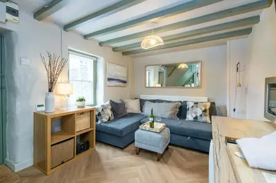 a living room with a blue couch and a table at Charming Welsh Cottage in Dolgellau - Snowdonia in Dolgellau