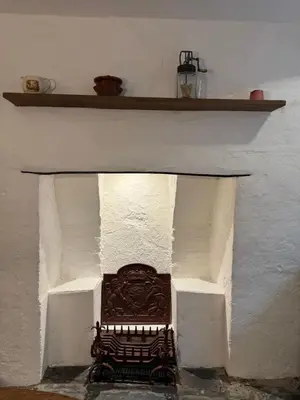 a fireplace with a bench in a white wall at Fishermans Cottage at The Old Library in Aberystwyth