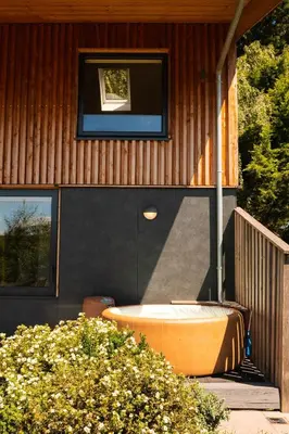 a house with a tub on the side of it at Amberwood Lodge in Hay-on-Wye