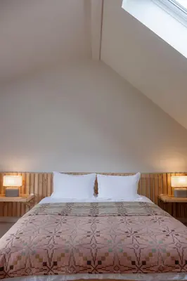 a bedroom with a large bed with two tables at Amberwood Lodge in Hay-on-Wye