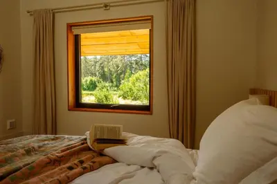 a bedroom with a window with a book on a bed at Brackenfell Lodge in Hay-on-Wye
