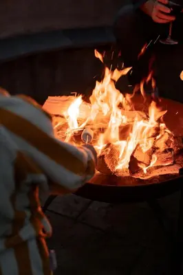 a person is reaching into a fire pit at Brackenfell Lodge in Hay-on-Wye