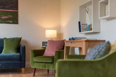 a living room with two chairs and a table at Cedar Lodge in Hay-on-Wye