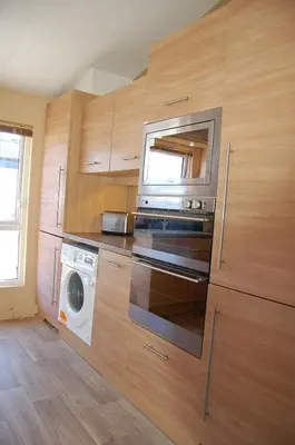 a kitchen with a washing machine and a microwave at Morannedd Lodge Barmouth Bay in Llanddwywe
