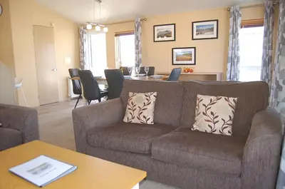 a living room with a couch and a table at Morannedd Lodge Barmouth Bay in Llanddwywe
