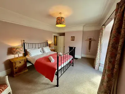 a bedroom with a bed with a red blanket at Victorian Town House Shrews in Shrewsbury