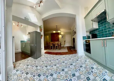 a kitchen with a table and a tile floor at Victorian Town House Shrews in Shrewsbury