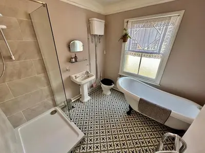 a bathroom with a tub and a toilet and a sink at Victorian Town House Shrews in Shrewsbury