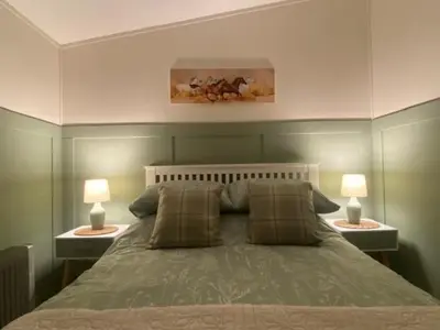 a bedroom with a bed with two lamps on both sides at Chalet 8 Erw Porthor Happy valley in Tywyn