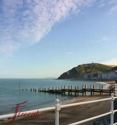 a pier in the water next to a beach at The Firecat Country House Guesthouse in Mallwyd