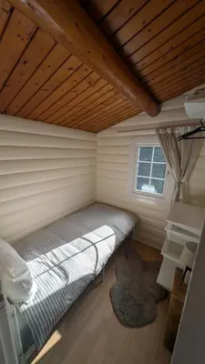 a bed in a small room with a window at IVY Cabin in Trawsfynydd