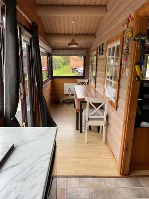 a dining area of a tiny house with a table and chairs at IVY Cabin in Trawsfynydd