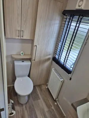 a small bathroom with a toilet and a window at Harries Superior Lodge Ocean in New Quay
