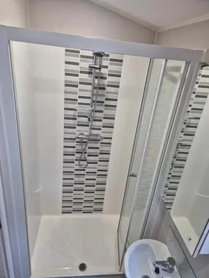 a bathroom with a shower and a sink at Harries Superior Lodge Ocean in New Quay