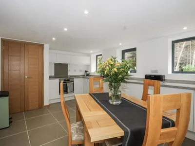 a kitchen with a table with a vase of flowers on it at The Barn in Bishops Castle