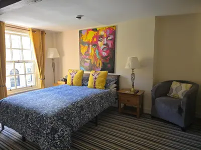 a bedroom with a bed and a painting on the wall at Family Room - The Unicorn Hotel in Llanidloes