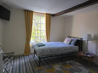 a bedroom with a bed and a large window at Family Room - The Unicorn Hotel in Llanidloes