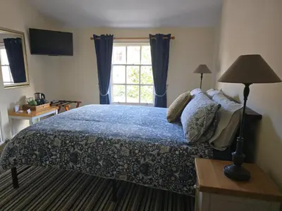 a bedroom with a large bed and a window at Cozy Double Room - The Unicorn Hotel in Llanidloes