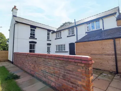 a brick retaining wall in front of a house at Preesgweene Farmhouse in Oswestry