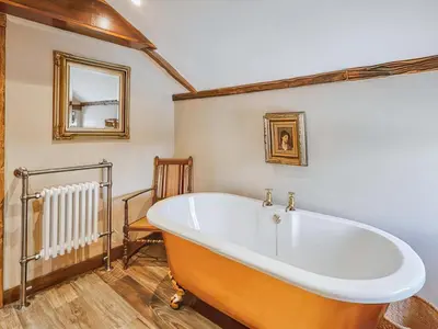a large bath tub in a room with a mirror at Rustic Retreat in Llangadog