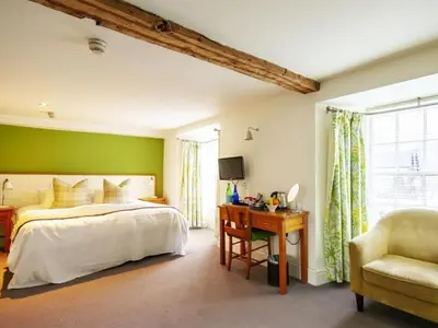 a bedroom with a bed and a desk and a chair at Y Meirionnydd Boutique Hotel in Dolgellau