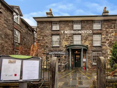 a stone building with a sign in front of it at Y Meirionnydd Boutique Hotel in Dolgellau