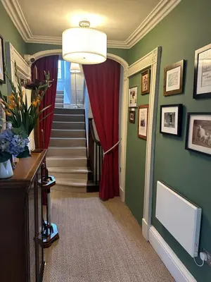 a hallway with a staircase with a red curtain at Y Meirionnydd Boutique Hotel in Dolgellau