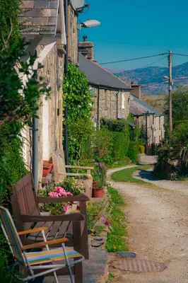 a group of benches sitting on the side of a building at Little Cott - Cosy Welsh Cottage, a hiking retreat in Maentwrog