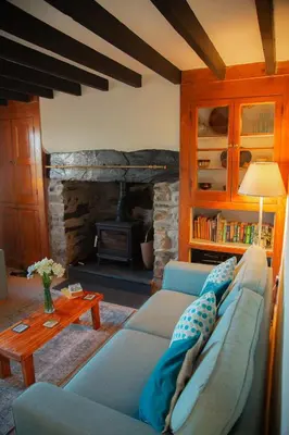 a living room with a couch and a fireplace at Little Cott - Cosy Welsh Cottage, a hiking retreat in Maentwrog