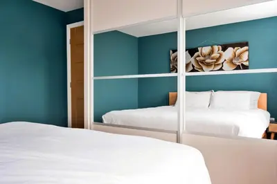 two beds in a bedroom with blue walls at Finest Retreats - Elizabeth House in Kington