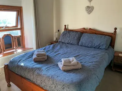 a bedroom with a bed with towels on it at Arddwyn - Cosy Welsh cottage in Penrhyndeudreath