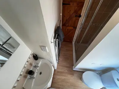 a small bathroom with a toilet and a sink at Arddwyn - Cosy Welsh cottage in Penrhyndeudreath