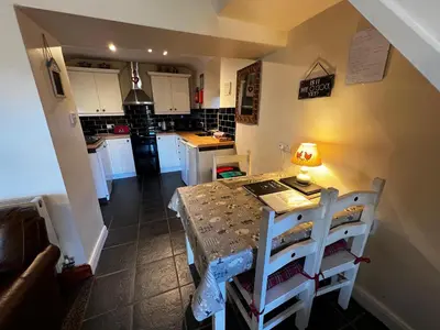 a kitchen with a table with a lamp on it at Arddwyn - Cosy Welsh cottage in Penrhyndeudreath