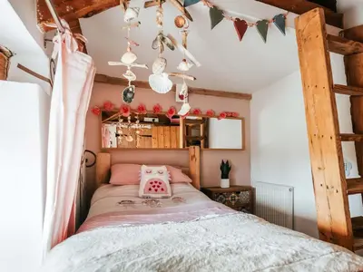 a bedroom with a bed with a pink pillow on it at Ty Fferm Bargoed in Aberaeron