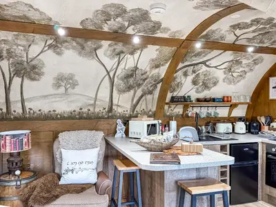 a kitchen with a mural of trees on the wall at Shires End in Leominster