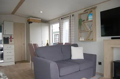 a living room with a couch and a tv at Premier Caravan 10 at The Vaenol, Tywyn in Tywyn